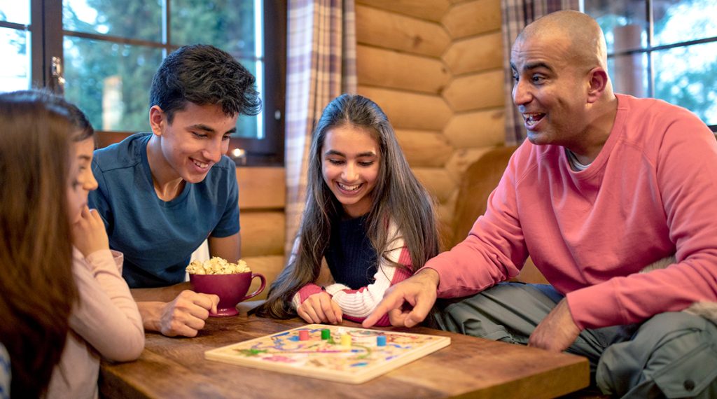 Family playing board games - family connection is one of the benefits of unplugging