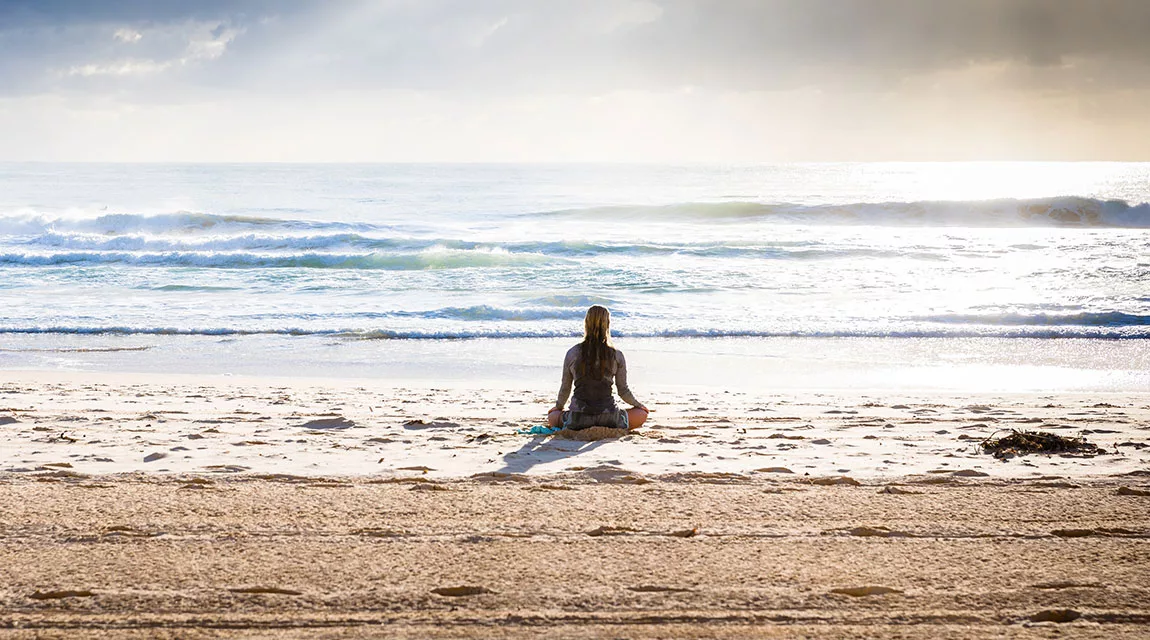 Girl on the beach during a meditation exercise